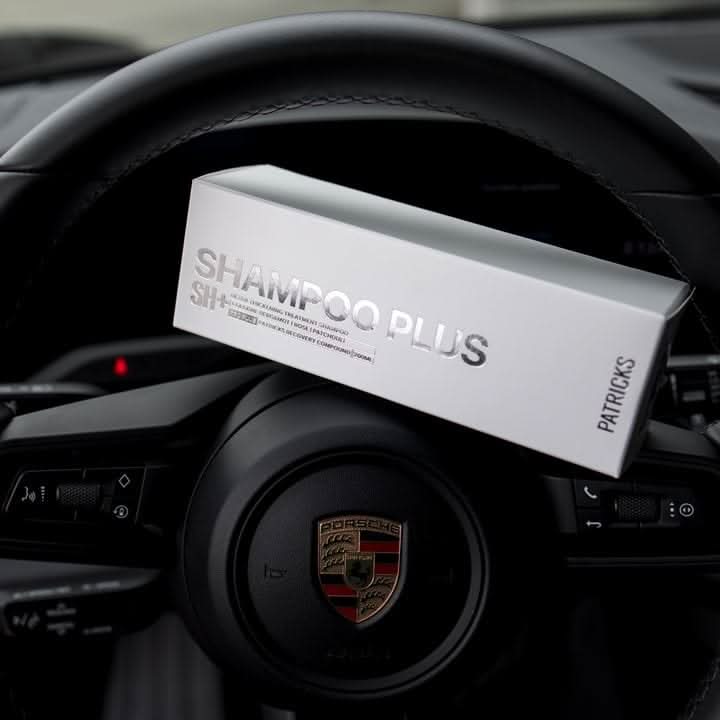 Patrick's thickening shampoo in white box packaging placed on a Porsche car steering wheel