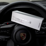 Patrick's thickening shampoo in white box packaging placed on a Porsche car steering wheel