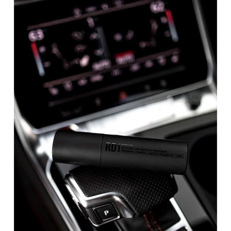 Patricks RD1 hair loss spray bottle placed on car gear shift console with black matte finish