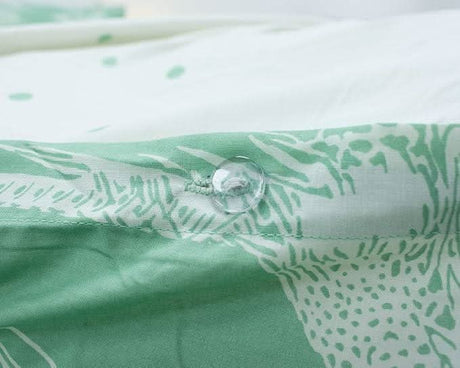 Close-up of button detail on green and white reversible bird print duvet cover from CLICKK Home Store