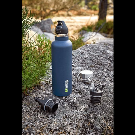CLICKK eco-friendly water bottle in blue on a rocky surface with detachable caps