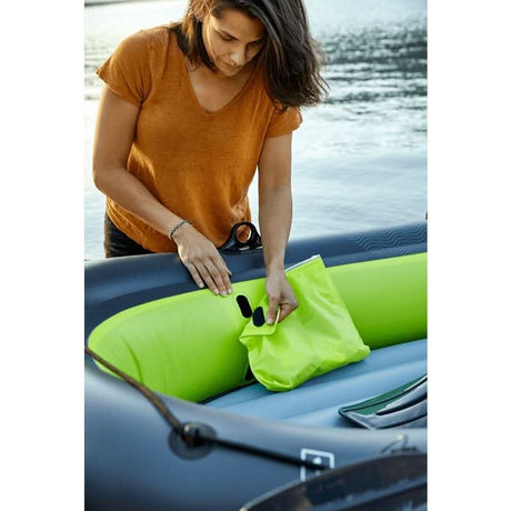 Person preparing an inflatable family boat with a vibrant green interior for a fun day on the water