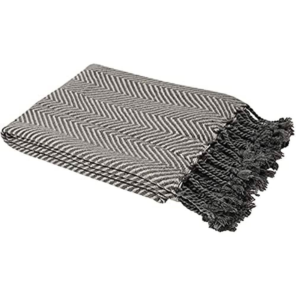 Folded Riva Paoletti Brasilia throw with black and white chevron pattern and fringed edges