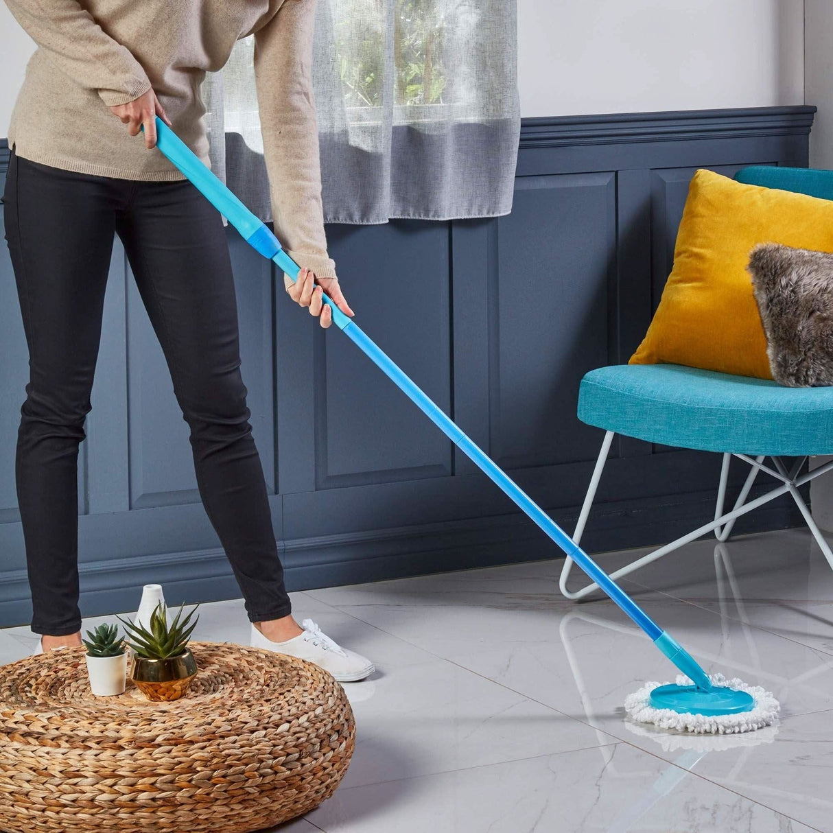 Person using Spontex twist mop set to clean glossy tiled floor in modern living room