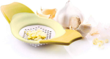 Calitek stainless steel garlic rocker kitchen tool with yellow handles and crushed garlic