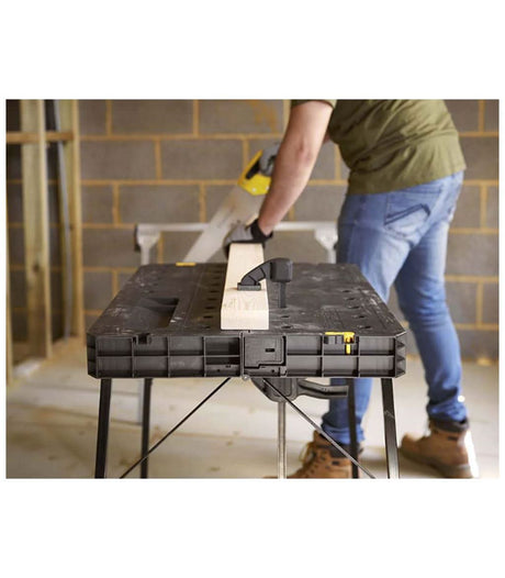 Black and Decker portable workbench for home use with clamp holding wood and person cutting wood