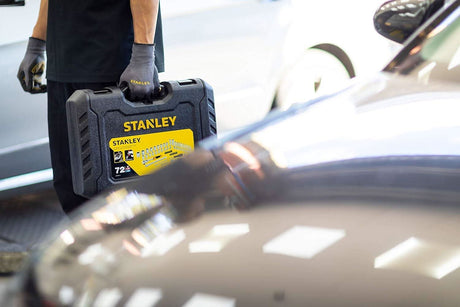 Black and Decker Stanley socket set 72 tooth in a durable carrying case held by a person near cars