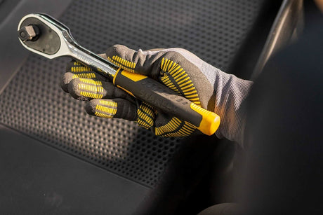 Hand wearing work gloves holding Black and Decker ratchet tool compatible with Stanley socket set 72 tooth