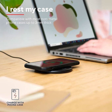 15W wireless charger by CLICKK Home Store charging a smartphone placed on a wooden desk near a laptop