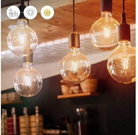 WiZ G95 LED filament bulbs hanging with warm glowing filaments in a cozy indoor setting