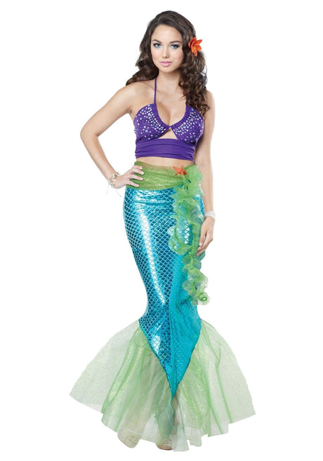 Woman wearing a women's mermaid costume XS with blue scaled tail and purple top with flower accessory