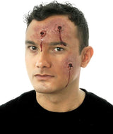 Man wearing Woochie latex body hits with realistic bullet wound makeup on forehead and cheek