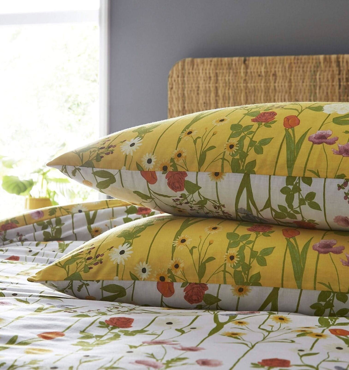 Yellow duvet cover super king with floral design and matching pillowcases on a wicker headboard bed